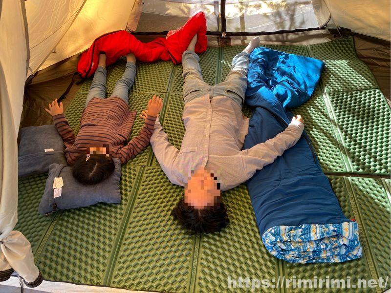 スカイパイロットTCの専用インナーテント内で、父親と子どもが寝そべってくつろいでいる様子の写真。家族3人で使っても圧迫感がない広さを示している。