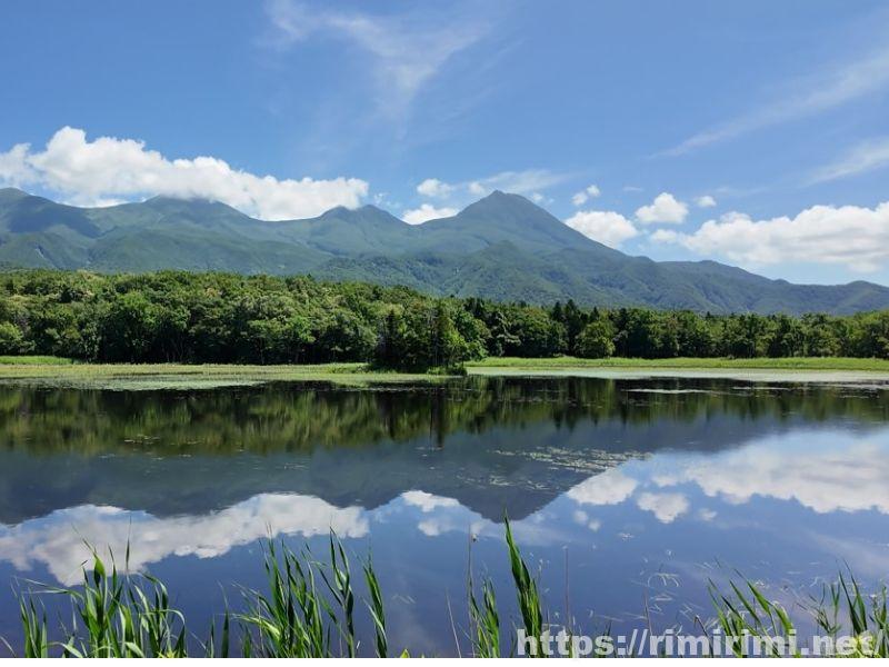 知床五湖の二湖。浮き草が浮かぶ湖面に空と山が映り込んでいる